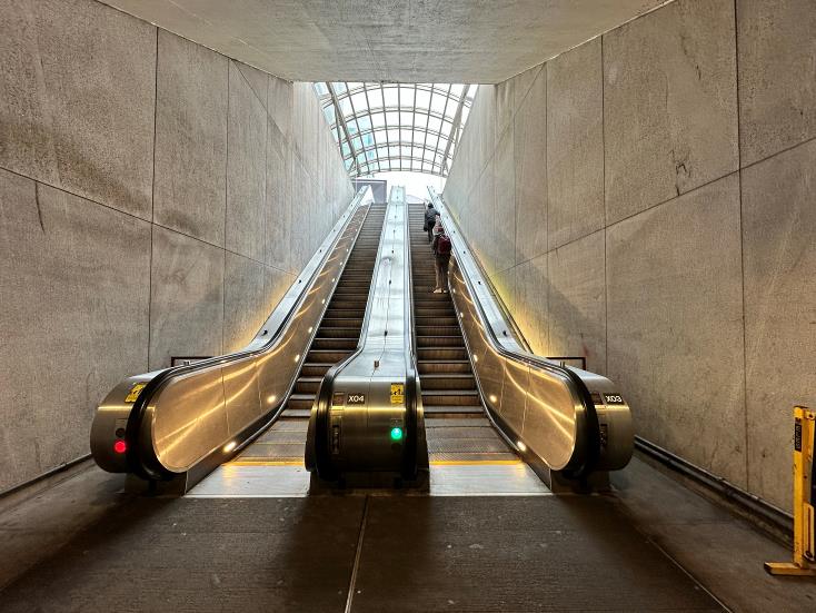 Continue up escalators from mezzanine level to street level. Do not enter mall.